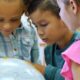 kids looking at a globe